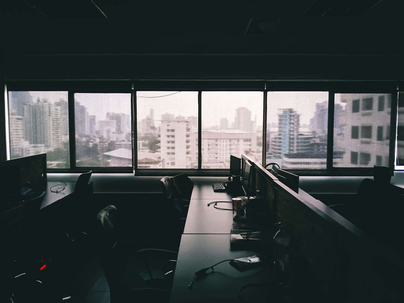 An analyst's desk facing floor-to-ceiling windows over the city